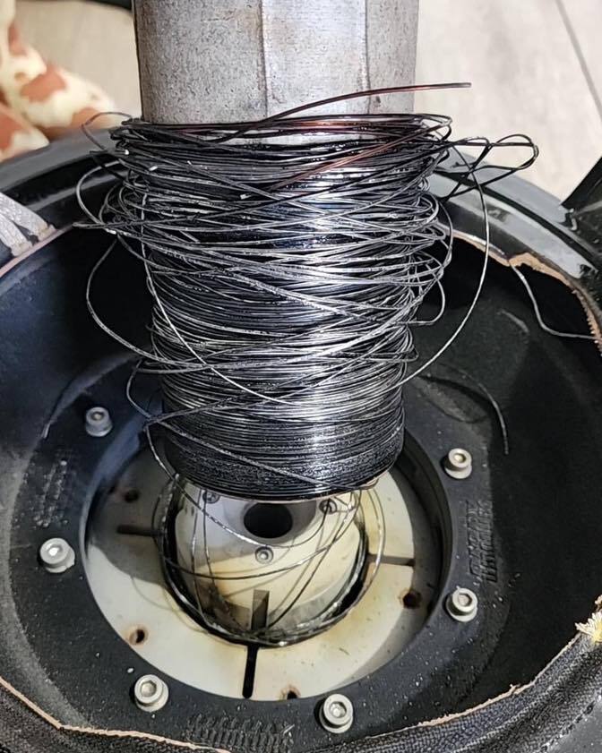 Sundown Audio subwoofer with burnt voice coil caused by clipping, showing damage during recone repair process and the need for subwoofer rebuild.