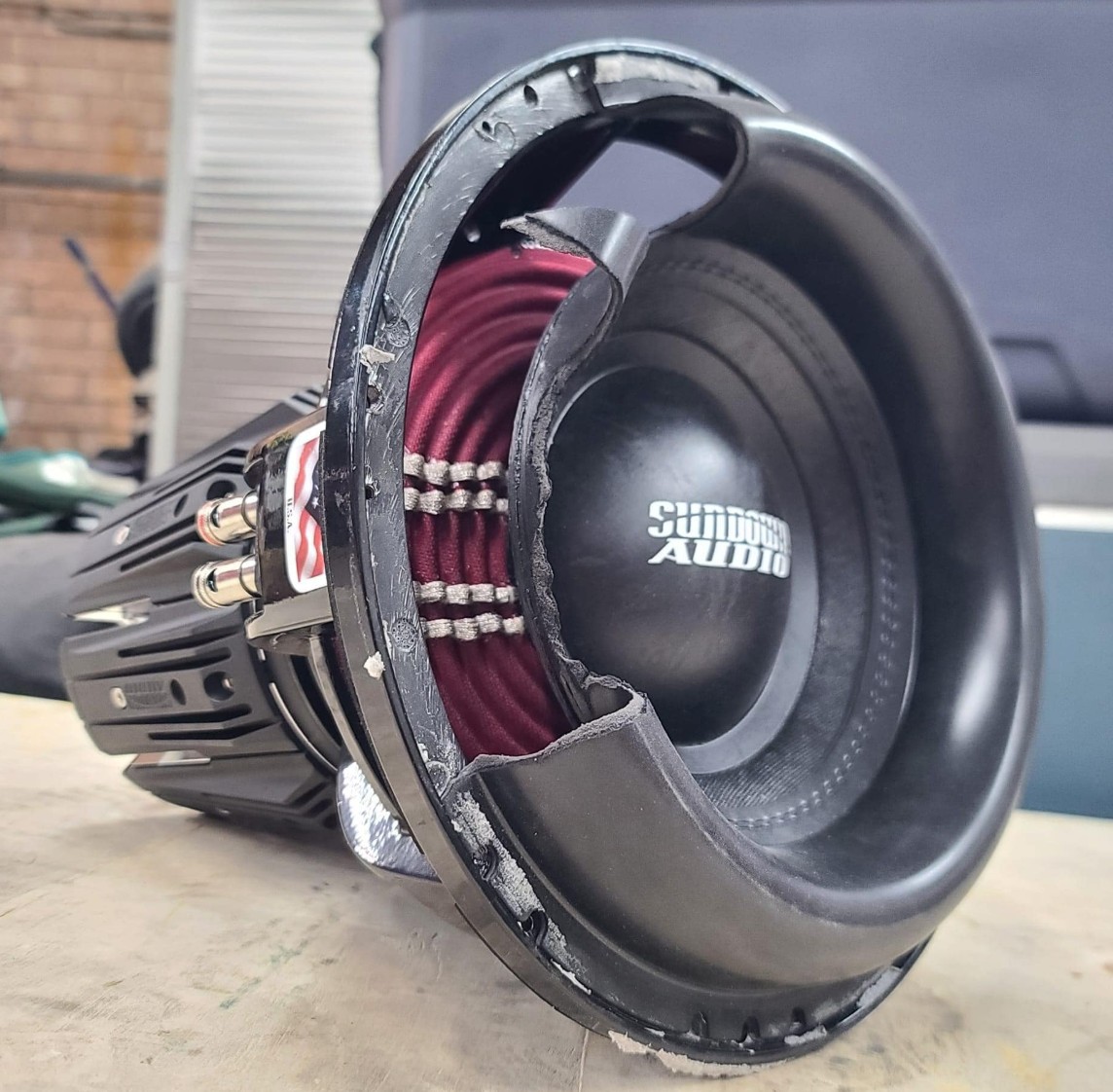 Sundown Audio NSv6 subwoofer during recone repair process, showcasing high performance subwoofer rebuild with new cone, spider, and voice coil for powerful bass output.